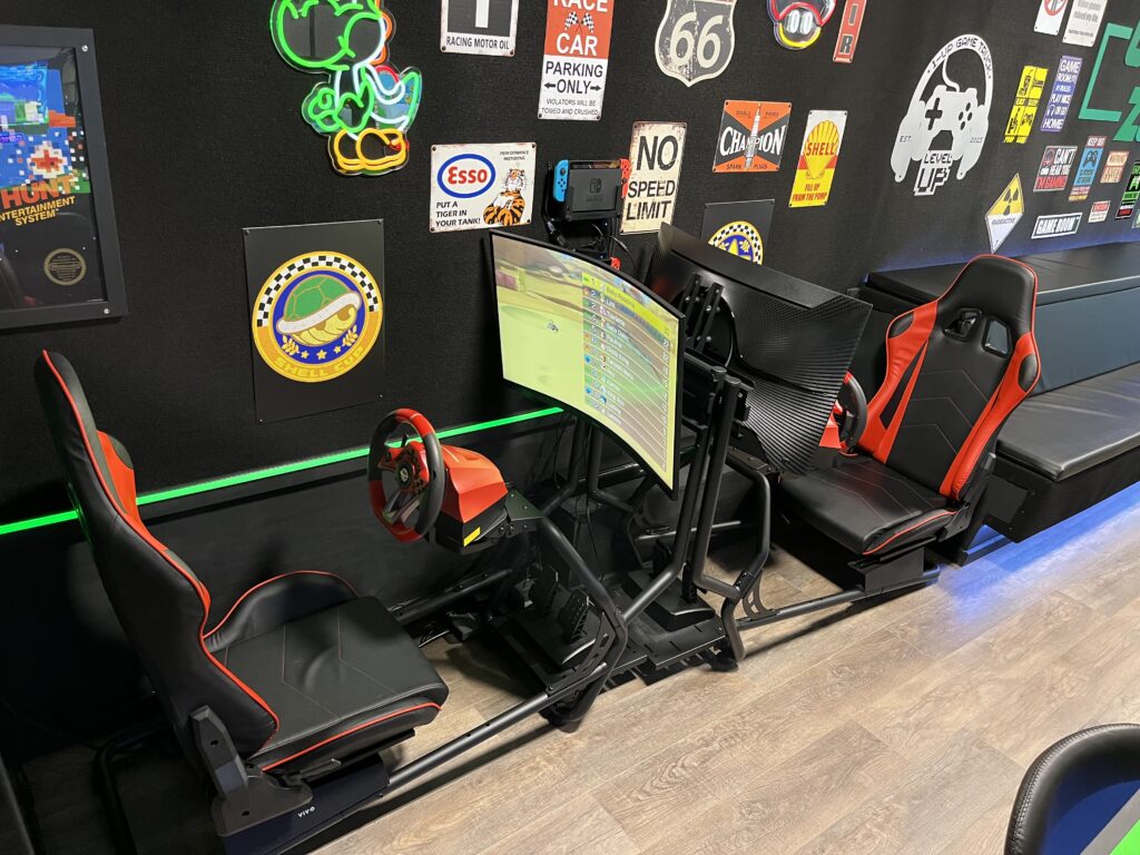 (2) Mario Kart Racing Simulators each equipped with a 32″ LED Gaming Monitor, adjustable racing seat, steering wheel and pedals ready for heads-up gameplay