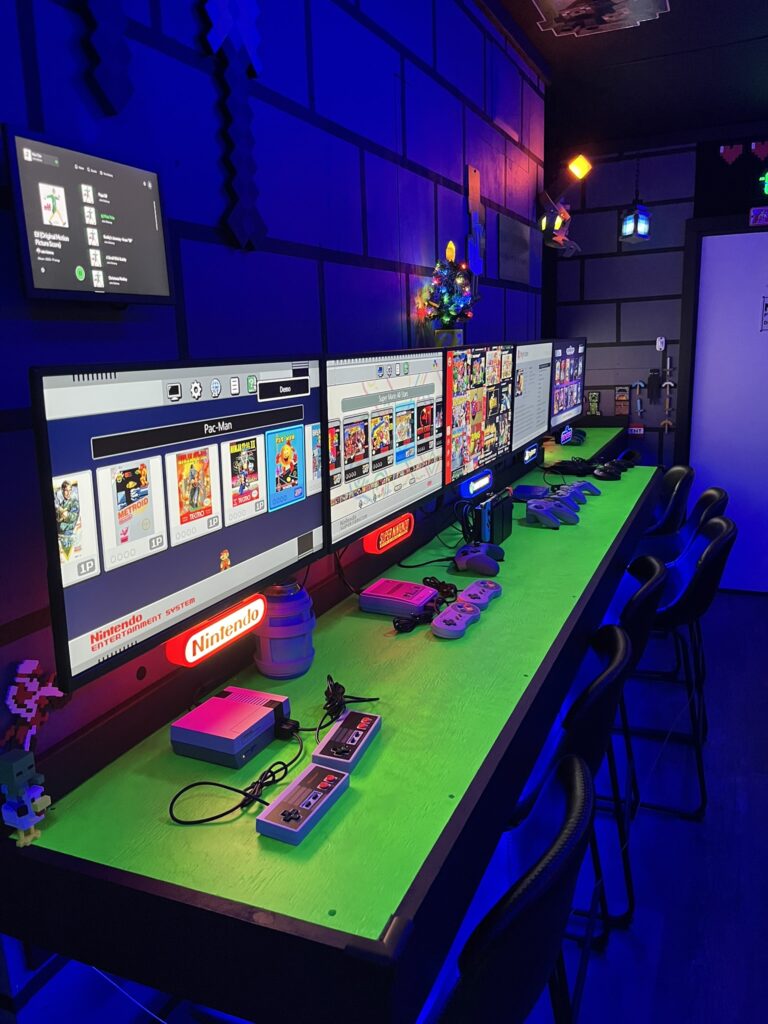 Retro gaming bar top: (4) Mini Classic consoles - NES, SNES, Sega Genesis, PS1 and a Nintendo Switch w/retro classics connected to (5) 24″ HDTV monitors